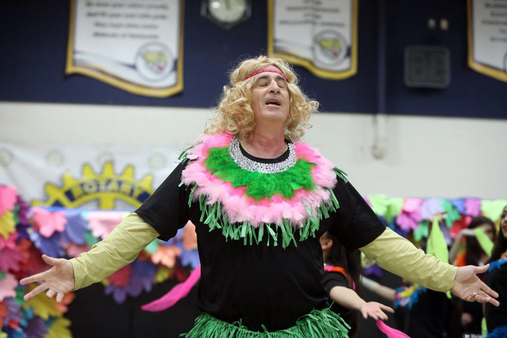 Tim Liles dressed up in a wig and grass skirt.